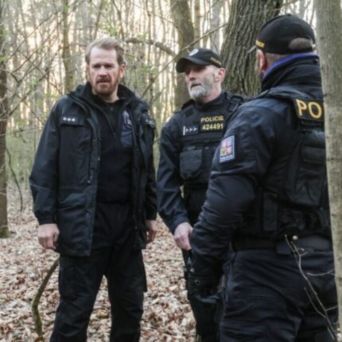 Policisté v uniformách zkoumají rozlomený strom v lese.